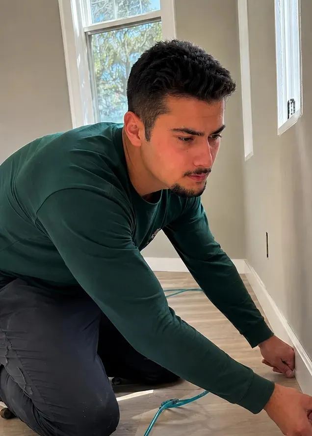 Guilherme Novelli installing baseboard trim in an Orlando home
